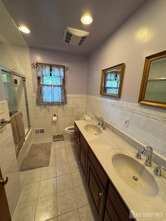 32 Gere Pl, Fanwood, NJ 07023 - bathroom with tile walls, tile patterned flooring, double vanity, wainscoting, and bath / shower combo with glass door