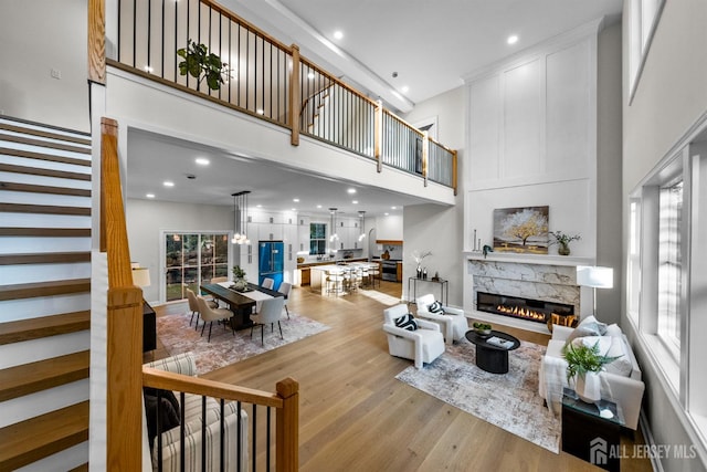 2 Beech Ln, Edison, NJ 08820 - living room featuring light wood finished floors, stairway, a towering ceiling, a stone fireplace, and recessed lighting