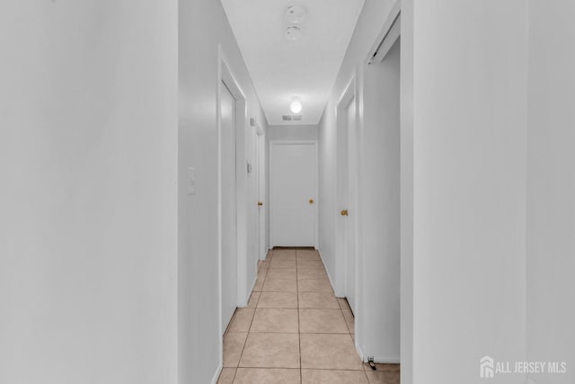 corridor with visible vents and light tile patterned flooring