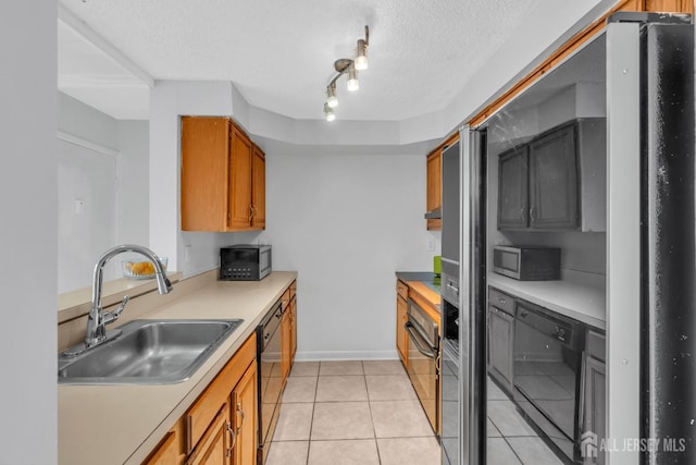 kitchen featuring black dishwasher, stainless steel microwave, brown cabinets, light countertops, and a sink