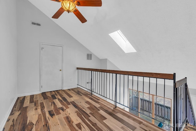 bonus room with high vaulted ceiling, a skylight, visible vents, and wood finished floors