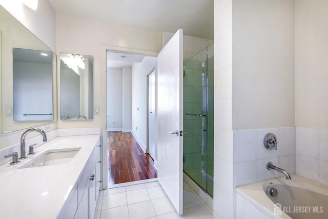 bathroom featuring a stall shower, vanity, a bath, and tile patterned floors