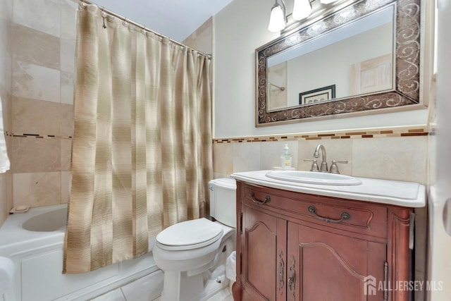 full bathroom featuring vanity, toilet, tile patterned floors, shower / bath combination with curtain, and tile walls