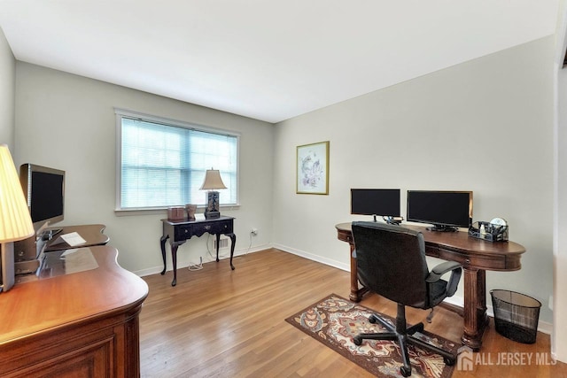 home office with baseboards and light wood-type flooring
