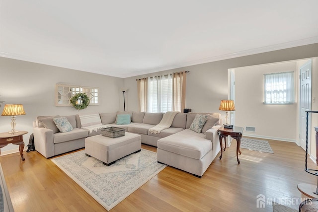 living area with plenty of natural light, light wood finished floors, and visible vents