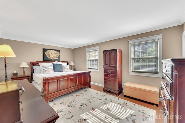bedroom with baseboards, ornamental molding, and light wood finished floors