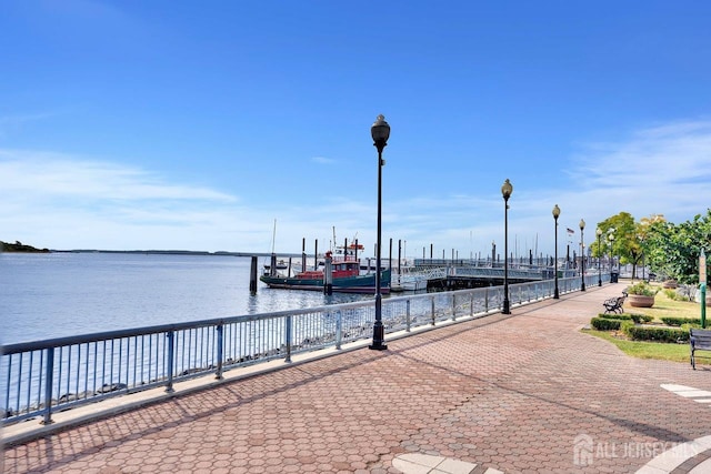 surrounding community with a water view and a dock