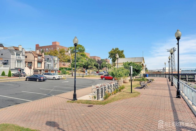 view of street featuring street lights, sidewalks, and curbs