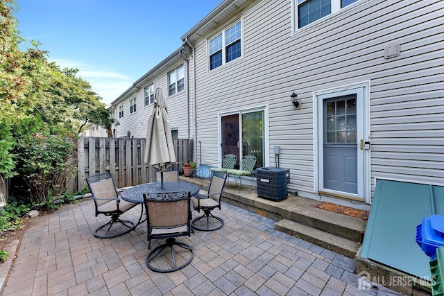 view of patio / terrace with central AC, fence, and outdoor dining space