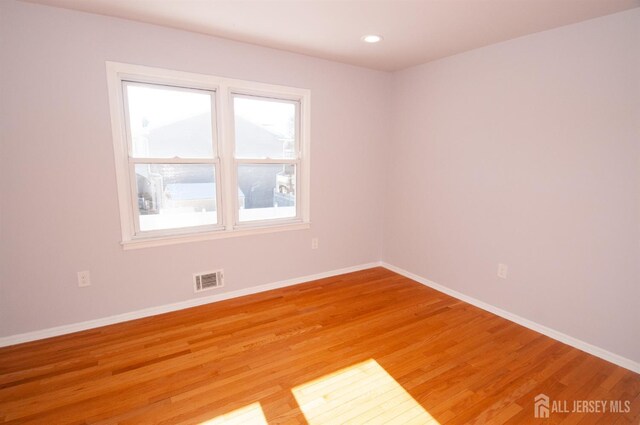 empty room featuring a healthy amount of sunlight and hardwood / wood-style flooring