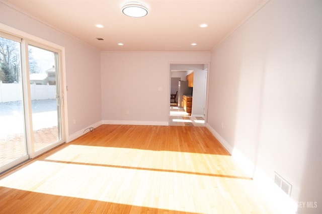 unfurnished room featuring ornamental molding and hardwood / wood-style flooring