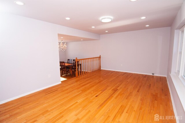 empty room featuring a chandelier and light hardwood / wood-style flooring