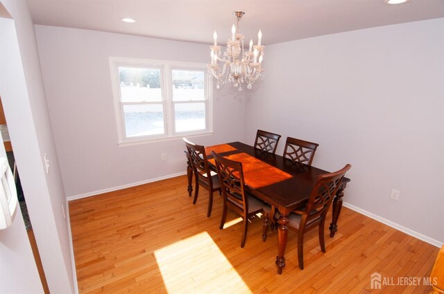 dining area with a chandelier and light hardwood / wood-style floors