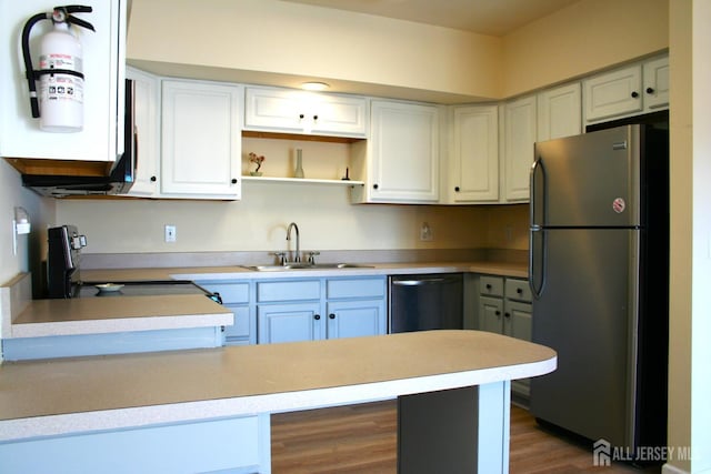 kitchen featuring freestanding refrigerator, a sink, stove, open shelves, and dishwasher