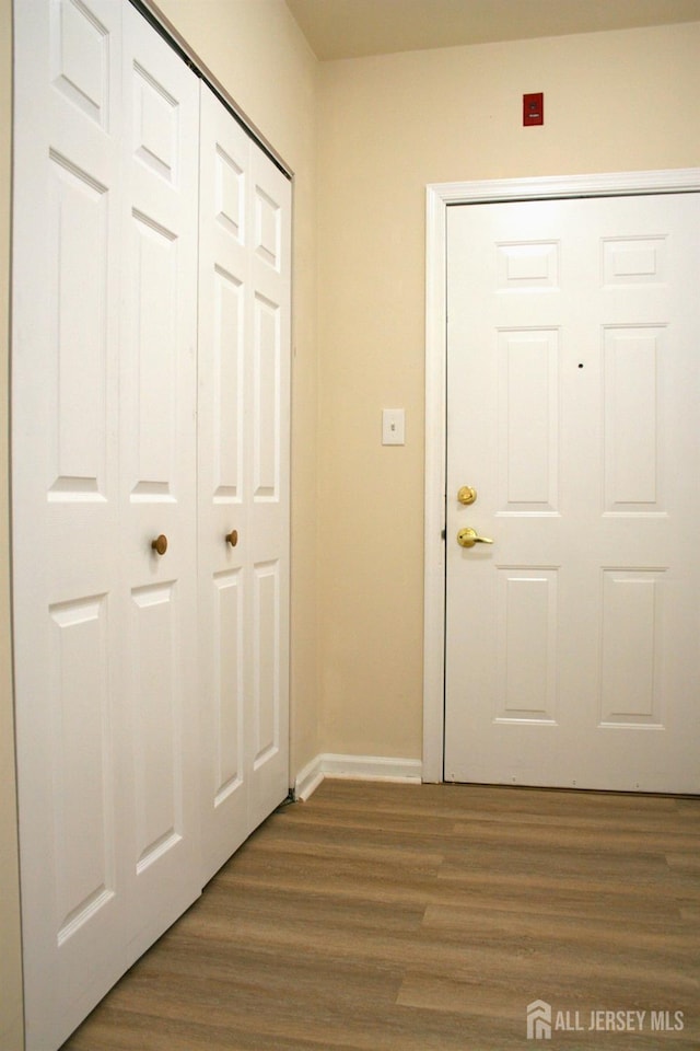 doorway featuring dark wood finished floors and baseboards