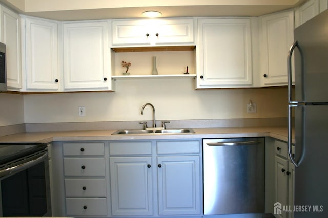 kitchen with freestanding refrigerator, dishwasher, a sink, range with electric stovetop, and light countertops
