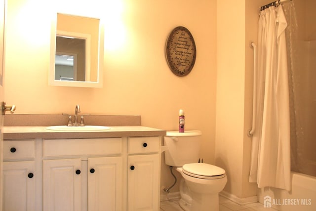 bathroom featuring toilet, tile patterned floors, vanity, shower / tub combo with curtain, and baseboards