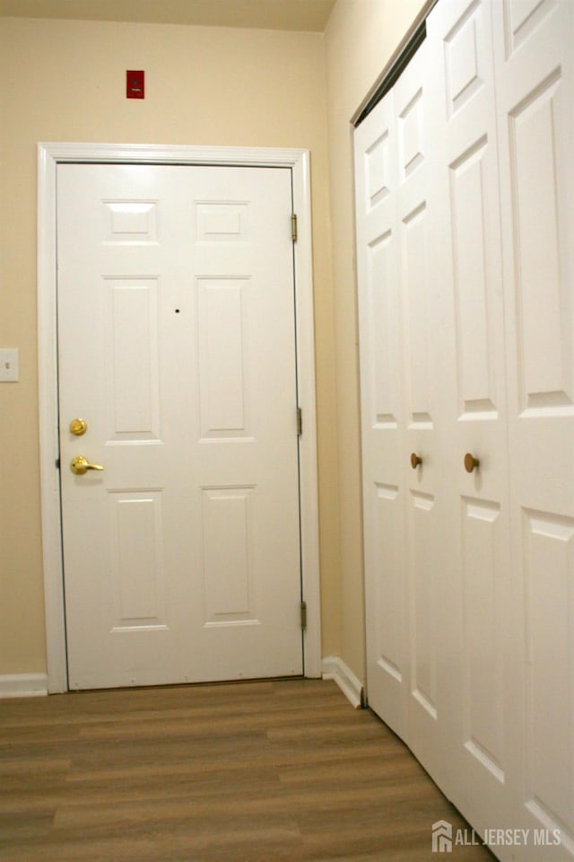 doorway to outside with dark wood finished floors and baseboards