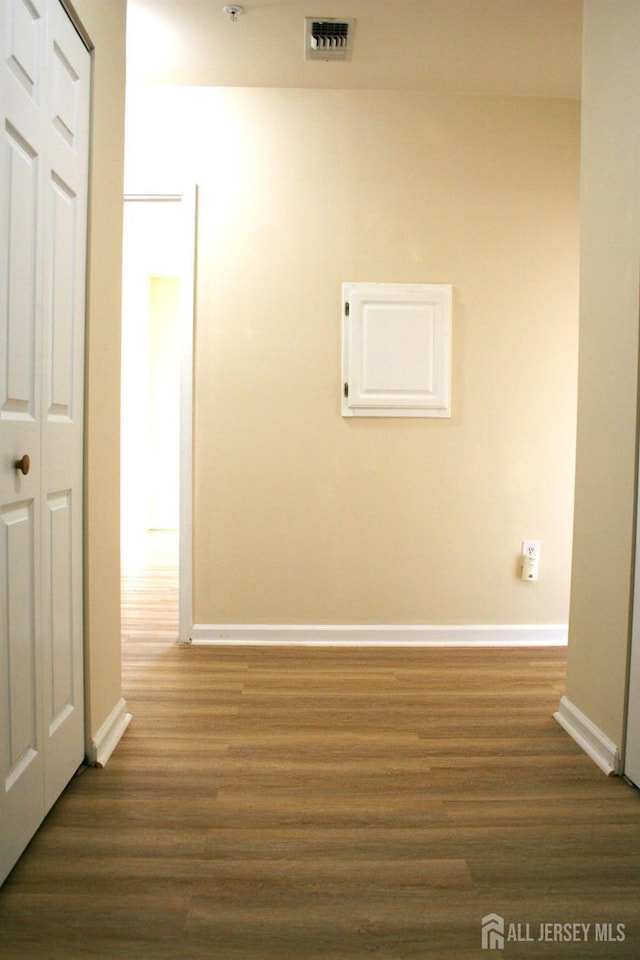 hallway with dark wood-type flooring and baseboards