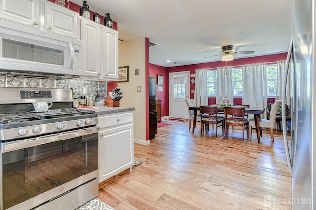 312 Bunnell Pl, Lacey, NJ 08731 - kitchen with appliances with stainless steel finishes, light wood-style flooring, ceiling fan, white cabinets, and tasteful backsplash