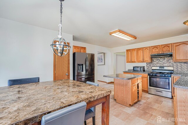220 Raritan St, South Amboy, NJ 08879 - kitchen with stainless steel appliances, under cabinet range hood, a breakfast bar area, a kitchen island, and a chandelier