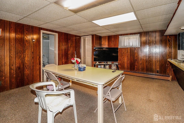 7 E 2nd St E, Port Reading, NJ 07064 - carpeted dining room featuring a paneled ceiling, wooden walls, and baseboard heating