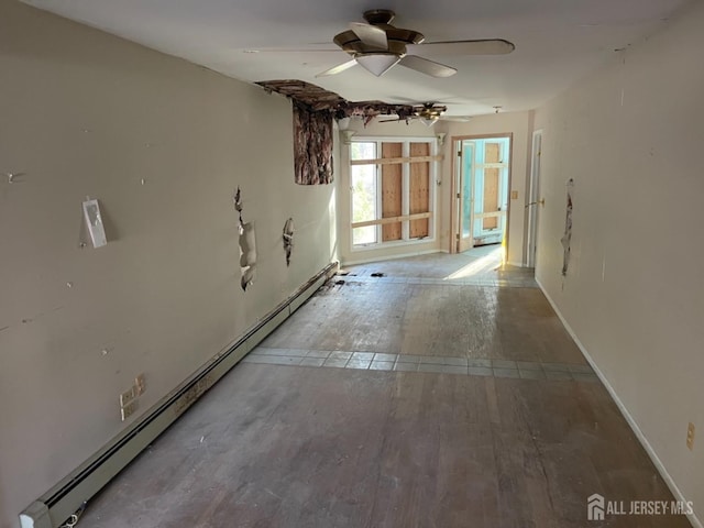 empty room with ceiling fan, baseboard heating, and wood finished floors