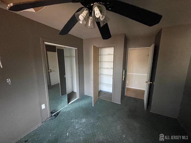 unfurnished bedroom with a ceiling fan and a closet