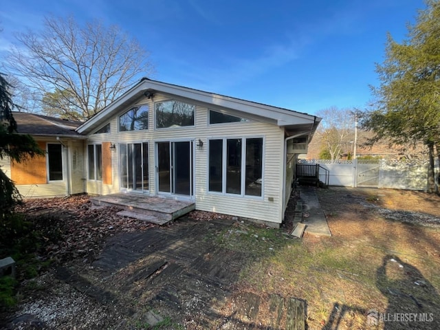 back of property featuring a gate and fence