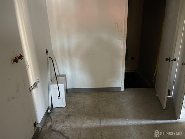 interior space with laundry area and baseboards