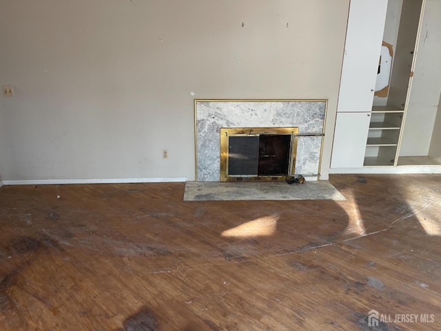 unfurnished living room with wood finished floors and baseboards