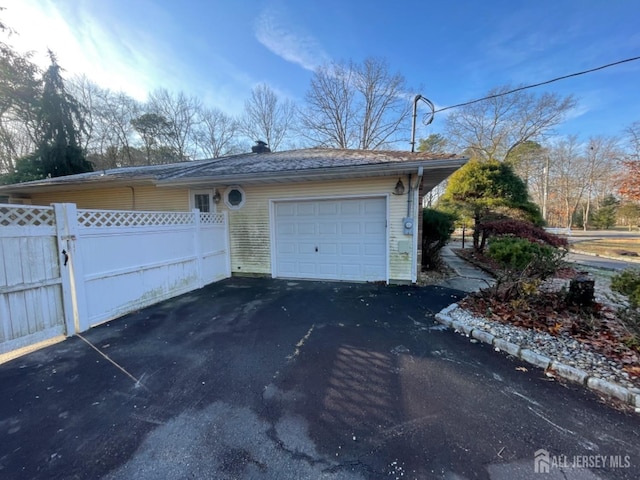 garage with driveway and fence