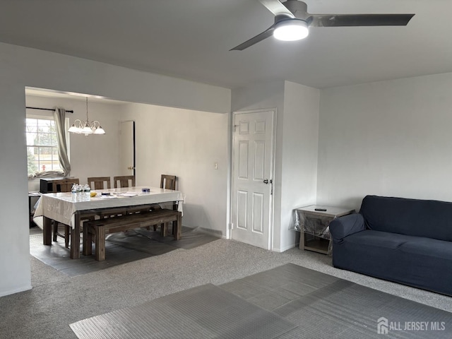 carpeted dining room with ceiling fan with notable chandelier