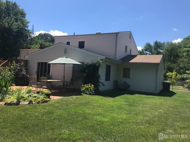 rear view of house featuring a yard and a patio area