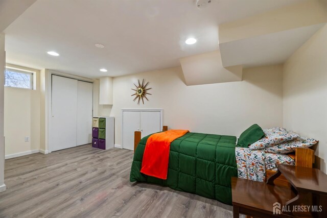 bedroom with baseboards, wood finished floors, and recessed lighting