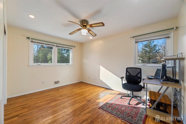 home office with hardwood / wood-style flooring and ceiling fan