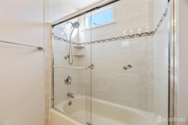 bathroom with bath / shower combo with glass door