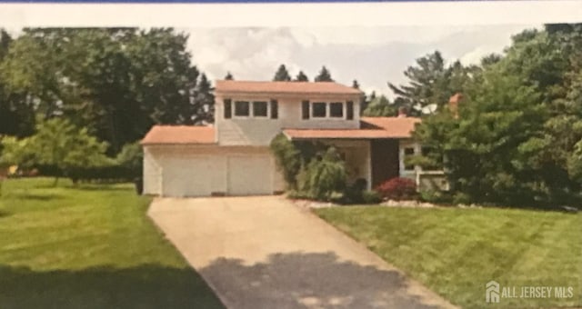 view of front of home with a garage and a front lawn