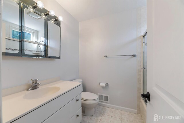 bathroom featuring tile patterned flooring, toilet, vanity, visible vents, and baseboards