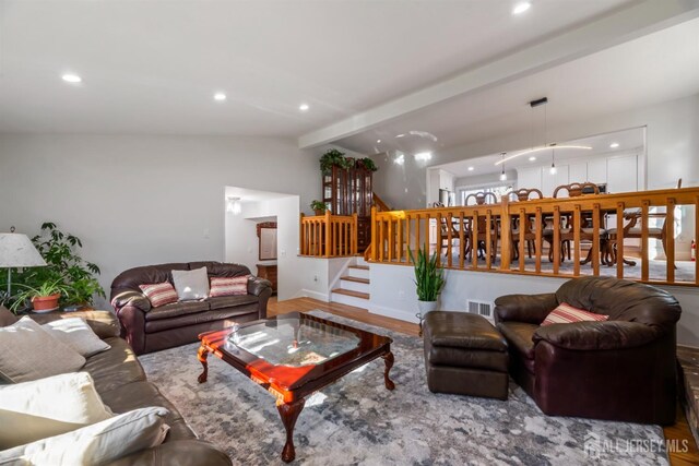 living area with vaulted ceiling with beams, recessed lighting, wood finished floors, baseboards, and stairs