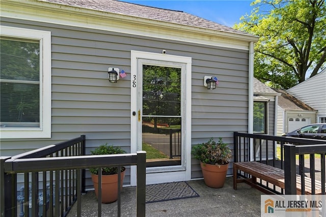 doorway to property featuring a shingled roof