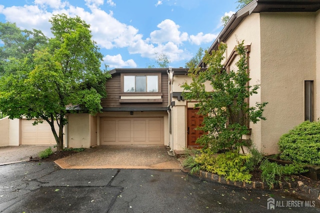 473 E Sayre Dr, Middlesex, NJ 08540 - view of property with stucco siding, driveway, and a garage