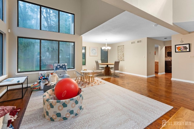 473 E Sayre Dr, Middlesex, NJ 08540 - living area featuring wood finished floors, a chandelier, and a towering ceiling