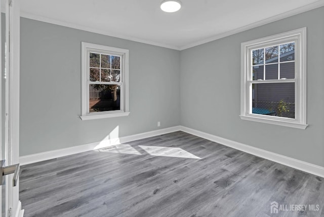 empty room with hardwood / wood-style floors and ornamental molding