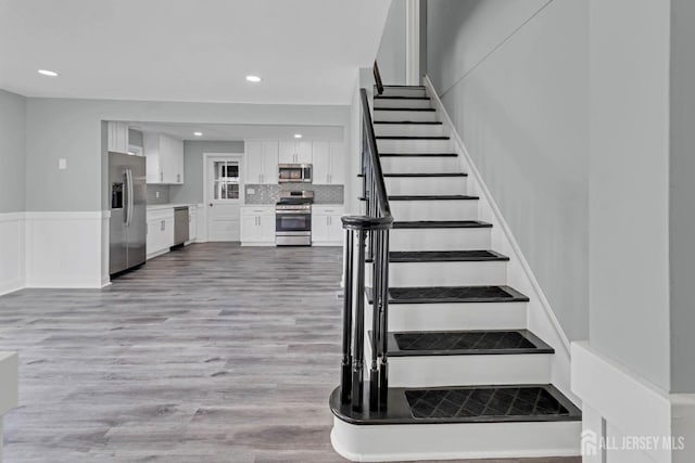 stairs featuring hardwood / wood-style floors