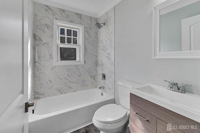 full bathroom with crown molding, wood-type flooring, toilet, vanity, and tiled shower / bath