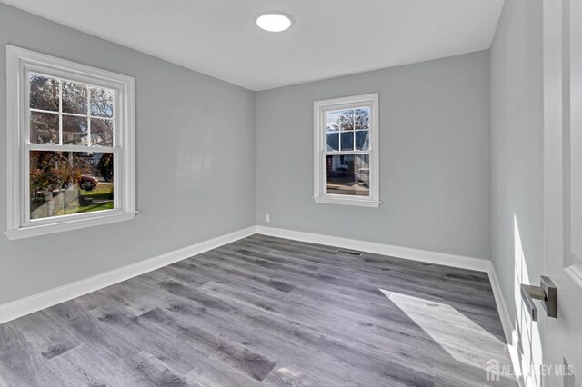 unfurnished room with wood-type flooring