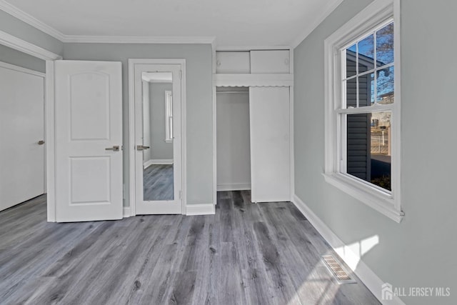 unfurnished bedroom with a closet, ornamental molding, and light wood-type flooring