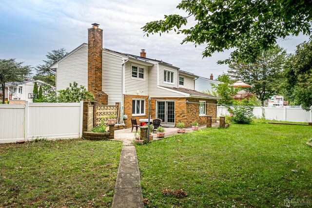 back of house with a patio and a yard