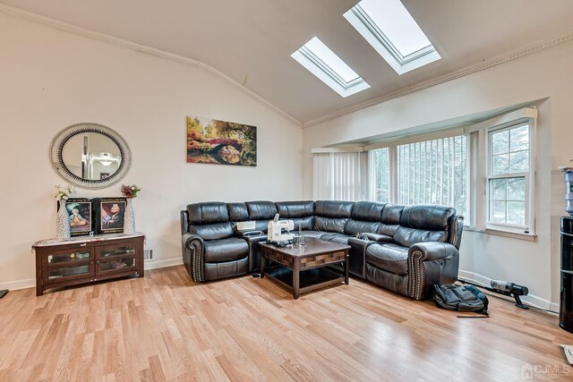 living room with vaulted ceiling with skylight, light hardwood / wood-style floors, and crown molding